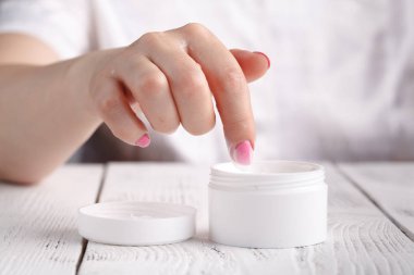 güzel kadın bir cilt bakım ürünü, nemlendirici veya Kuru cildi dikkat çekici losyon kullanarak. Eller içinde nemlendirici krem