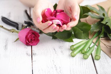 Düğün için gül yaprakları dolu bir çiçekçi kadın eli