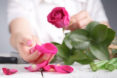 Çiçekçi bir buket yapar.