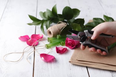 Çiçekçi bir buket yapar.