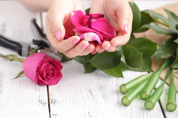 Düğün için gül yaprakları dolu bir çiçekçi kadın eli