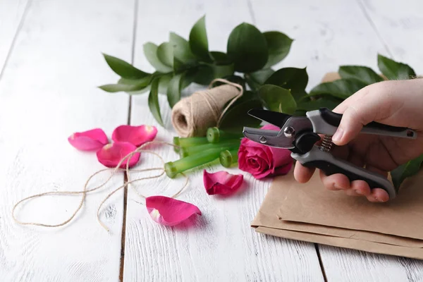 Çiçekçi bir buket yapar.