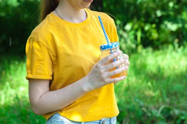 Kadın eli, portakal suyu ile cam kavanoz closeup detoks