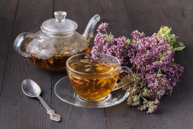 çay ahşap masa üzerinde bitki kekik ile