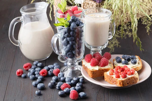 Healthy vegan breakfast. Oatmeal granola with oat milk and berries over wooden table background. Clean eating, weight loss, vegetarian, raw food concept