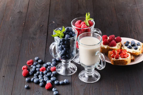 Overnight oats with fresh blueberries in jars on a rustic wood background