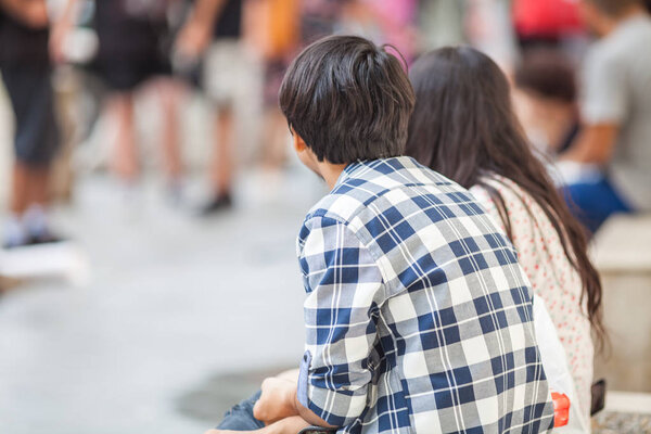 Young people sit on sunny street