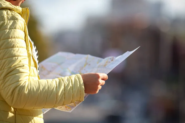 Tourist holding map paper with finding location for travel in city