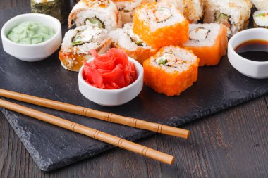 Kara kayrak taş üzerine çeşitli suşi yemek servis