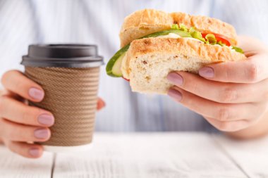 Kadın et ve wegetables büyük bir sandviç yiyor