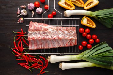 Çiğ et. Bir kesme tahtası sebze ve otlar ile ham sığır eti biftek.