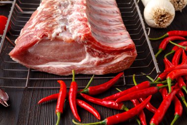 Karanlık masada yemek pişirmek için malzemelerle çiğ taze et