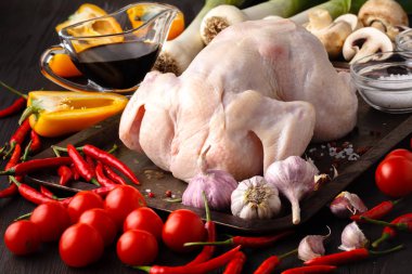 Çiğ çiğ tavuk, ahşap tahta üzerinde ızgara, et yemek pişirmek için malzemelerle