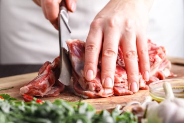 Adam kesme rack kuzu lokanta mutfağı, ahşap tahta üzerinde. Şef yemek için taze et hazırlama