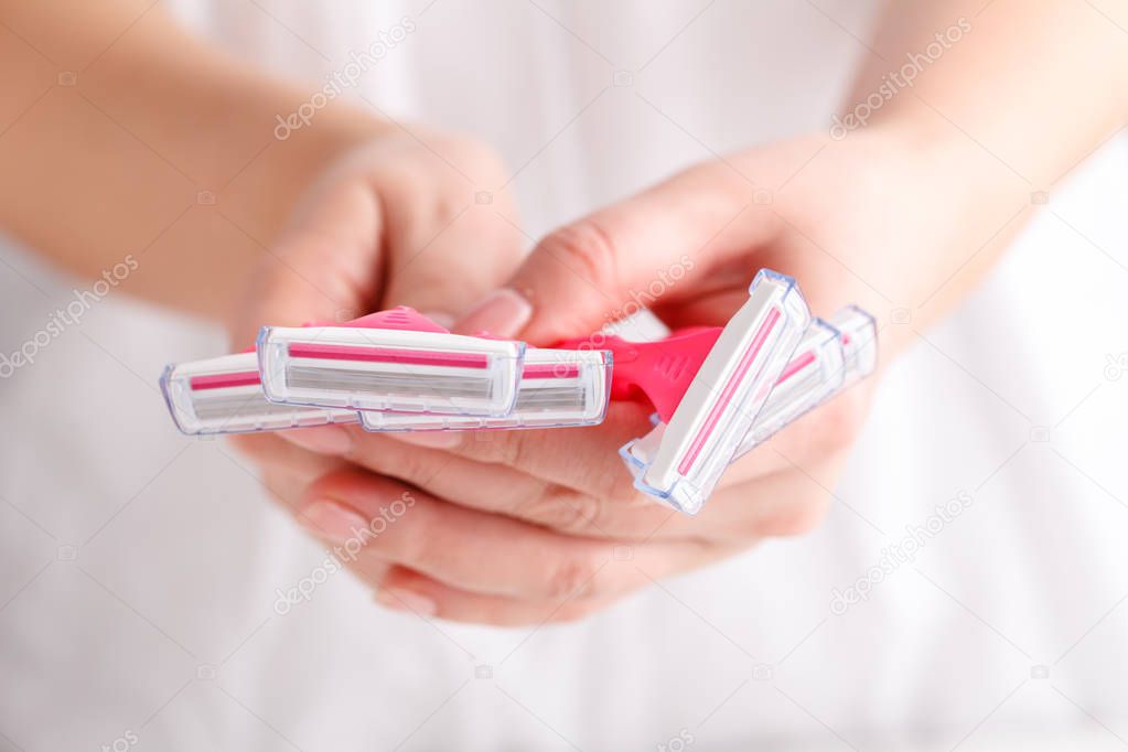 Pink female razors in hands on the white background. Set of razors on white background. Pink women's disposable razors