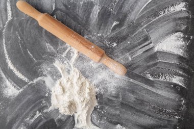 Oklava ve un siyah masada. Uzay kopyalayın. Üstten Görünüm