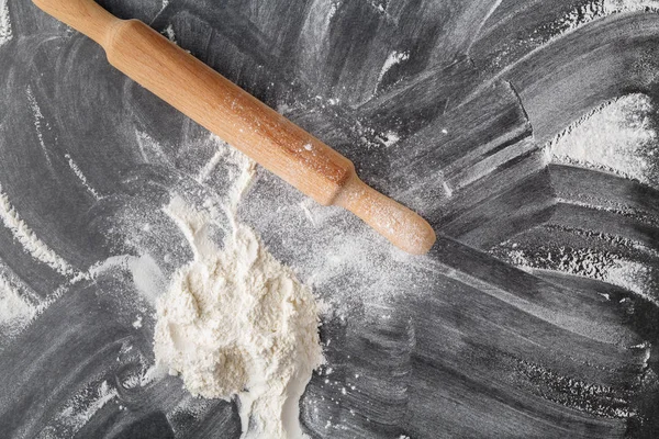 bir oklava siyah bir zemin üzerine beyaz un