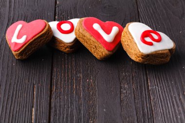 Sevgililer günü hediye kutusu eski vintage ahşap plakalar üzerinde kelime aşk kalp şeklinde. Tatlı tatil arka plan gül yaprakları, küçük kalpler ile bükülmüş şerit