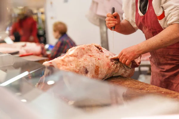 Butcher sells chopped beef meat at a market — Stock Photo, Image