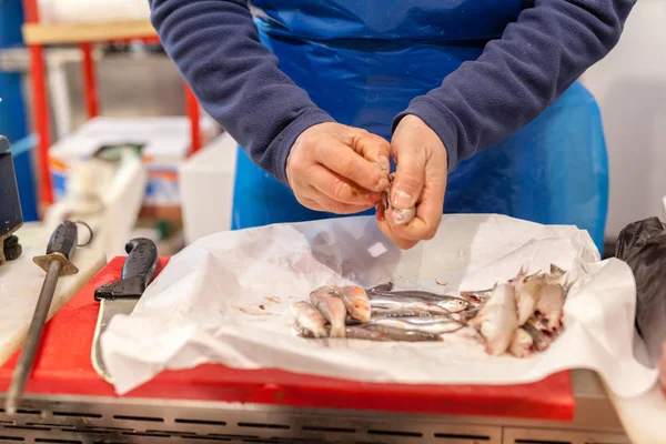 Vendedor cortando pescado. Una escena típica en el mar tradicional de pescado — Foto de Stock