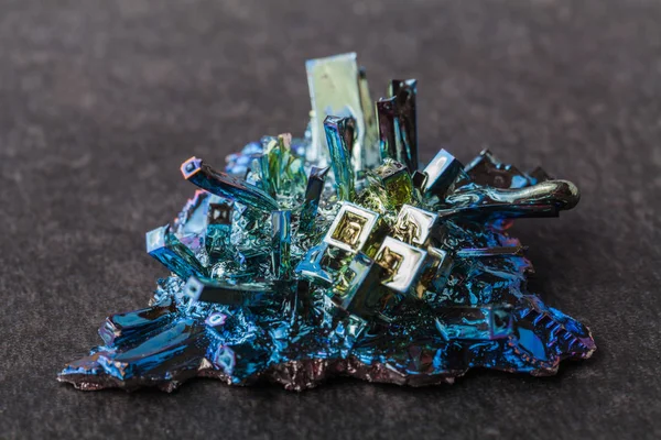 Crystal of bismuth on dark stone background — Stock Photo, Image