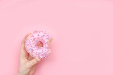 sırlı pembe çörek üzerinde pembe bir tek renkli backgro tutan kız