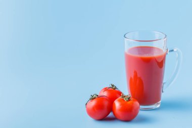 Taze domates ve bir bardak domates suyu.