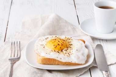 lezzetli breakfast - sıcak Fransız tost, emmental peyniri erimiş ve bir beyaz fincan kahve bir tablo ile tabakta Yumurta kadar güneşli tarafı kızarmış