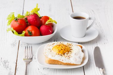 Çıtır çıtır kızarmış ekmek bir sahanda yumurta ve taze roka, bir fincan kahve, otel odasında kahvaltı