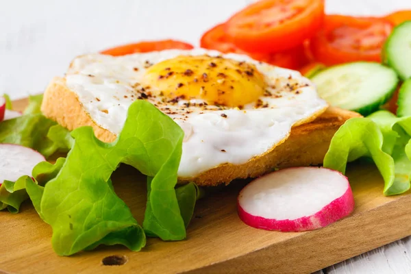 Roti lapis lezat dengan alpukat, tomat dan telur rebus di papan kayu potong — Stok Foto