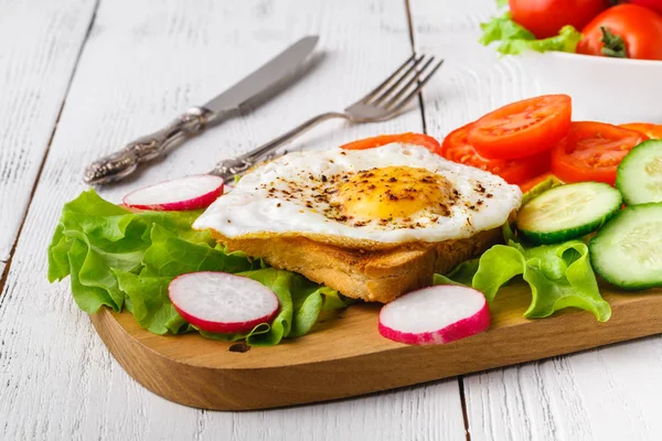 Śniadanie - chleb tosty z jajkiem sadzonym, przyprawy i rukolą — Zdjęcie stockowe