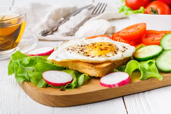 Vynikající snídaně - horké francouzské toasty, roztavený sýr Ementál a smažené volské oko vejce, podávané na bílé plotně šálek kávy na stole — Stock fotografie