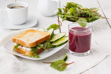 Rustik ahşap masada keçi peyniri, avokado, roka ve güneş kurutulmuş domates ile sağlıklı tost