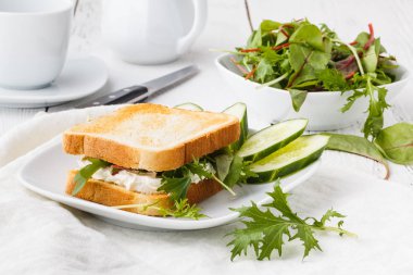 Rustik ahşap masada keçi peyniri, avokado, roka ve güneş kurutulmuş domates ile sağlıklı tost