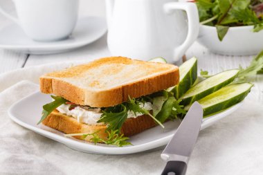 Rustik ahşap masada keçi peyniri, avokado, roka ve güneş kurutulmuş domates ile sağlıklı tost