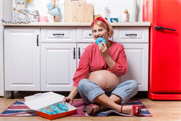 Zwangere vrouw met buik houden donut. Het concept gewicht vervolg — Stockfoto