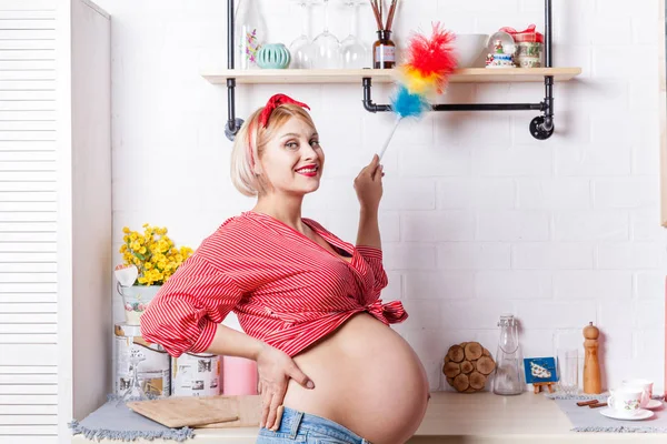 Jonge zwangere vrouw iinduceert netheid in de keuken met pi — Stockfoto