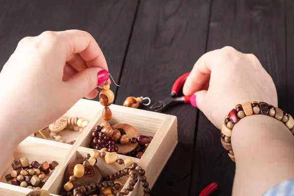 Elaboración de joyas artesanales. Caja con cuentas en mesa de madera vieja. —  Fotos de Stock