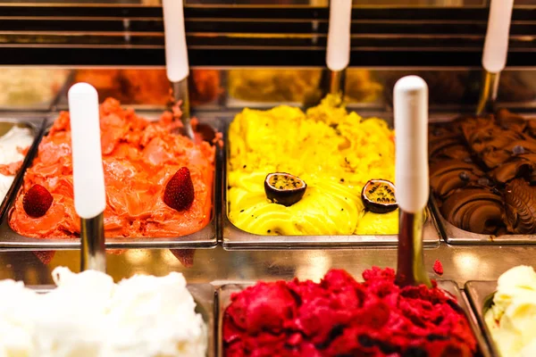 Heladera heladera con crema y fruta Helado italiano de acero que sirve mostrador con muchos de refrescantes sabores dulces y palpables. Exhibición del helado, varios sabores del helado del helado —  Fotos de Stock