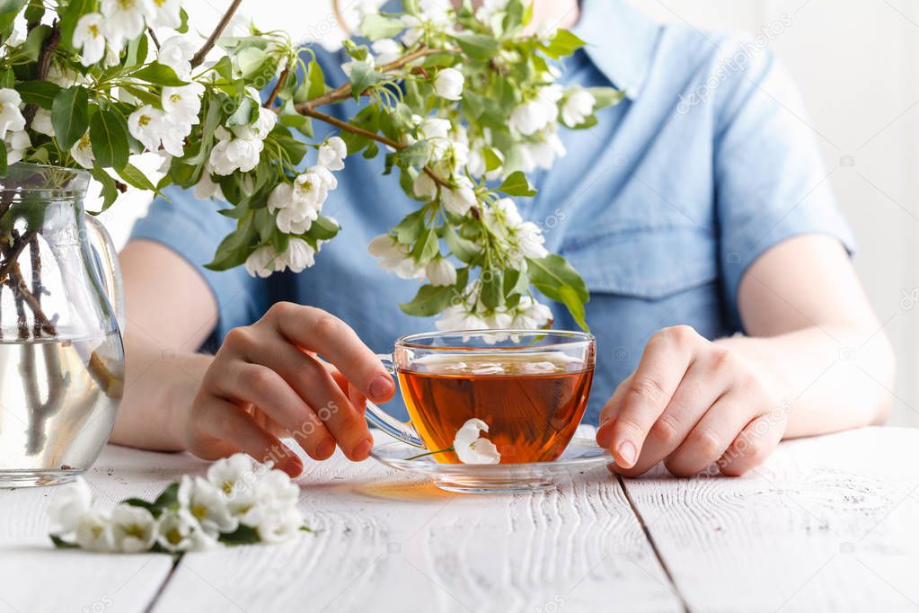 spring morning, the girl drinks tea with a bouquet of spring app