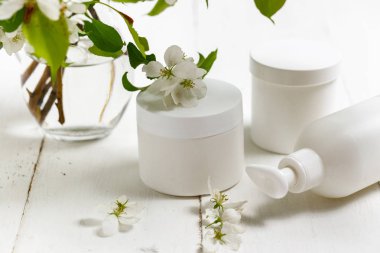 Kozmetik şişe beyaz bahar çiçekleri ile yakın 