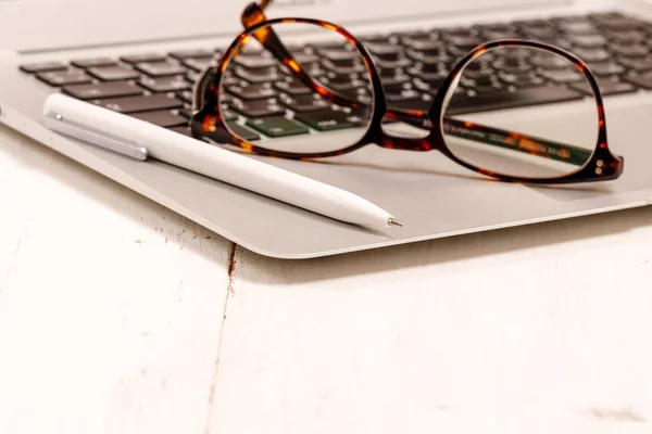 Sideview íróasztal, laptop, szemüveg és egyéb elemek a — Stock Fotó