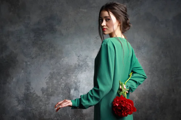Adorable femme portant une robe élégante tenant une fleur de pivoine rouge — Photo