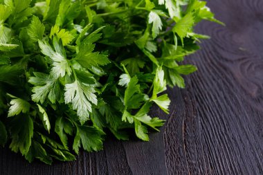 Ahşap masa arka plan üzerinde maydanoz demet. Taze çiğ maydanoz planı
