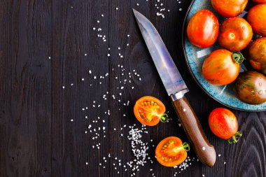 Koyu bir arka plan üzerinde bir tabakta taze domates. Hasat tomat