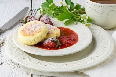 Ev yapımı süzme peynirli krep tabağında çilekli Rus şurubu. Kahvaltı zamanı.