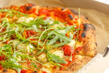 Mukavva içinde çeşitli malzemeler ve peynirli pizzaları kapatın. Tahta masanın kapağı açık olan kutuları çıkarın.