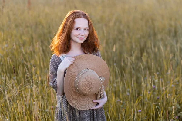 日没時に牧草地にポーズをとる赤毛のモデル — ストック写真