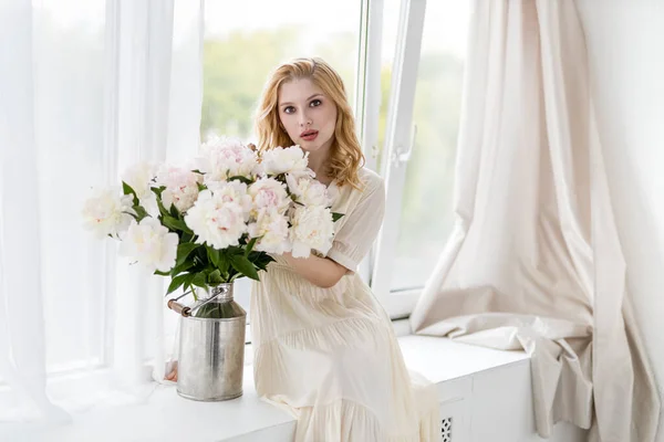 실내에서 흰색과 향기를 아름다운 소녀가 꽃다발을 즐기며 — 스톡 사진