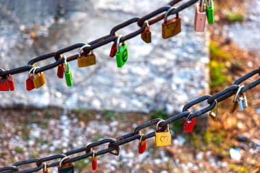 Metal zincirdeki asma kilit romantizmi simgeler. Metal bir zincire bağlanmış renkli aşk kilitleri. Romantik yerlerde bulunan sonsuz aşkı ve bağlılığı simgeliyor.